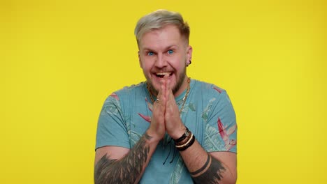 un hombre sonriente con cabello rubio y una barba en una camisa azul con flores