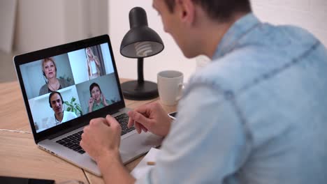 tecnología, trabajo remoto y concepto de estilo de vida - hombre feliz con computadora portátil teniendo video chat y agitando la mano en la oficina de casa