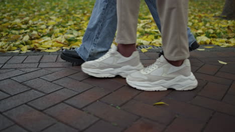 man and woman legs walking in city park