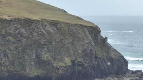 Primer-Plano-De-Un-Dron-De-Altos-Acantilados-Con-Cascadas-Y-Pájaros-En-La-Isla-Achill