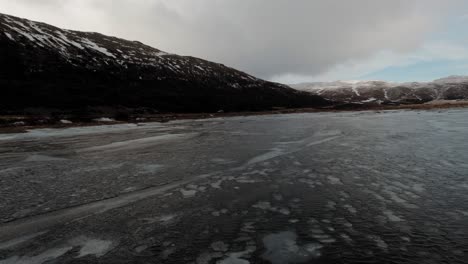 icy sea water and coastline view of iceland in winter - aerial shot