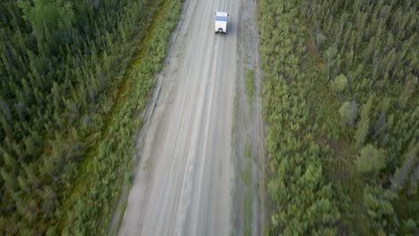 Von-Oben-Nach-Unten-Geschossen,-Wohnmobil-LKW,-Der-Auf-Einer-Unebenen-Straße-Im-Fichtenwald-Fährt