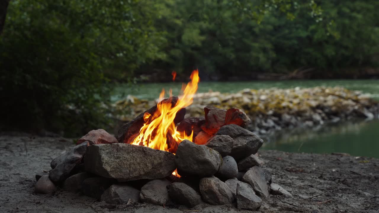 Fire pit beside flowing river in the mountains during a calm rain storm