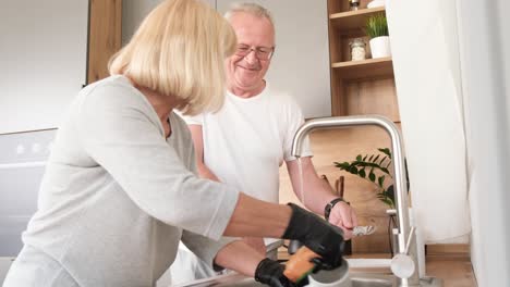 australian retirees wash dirty dishes after breakfast an elderly couple spends time together
