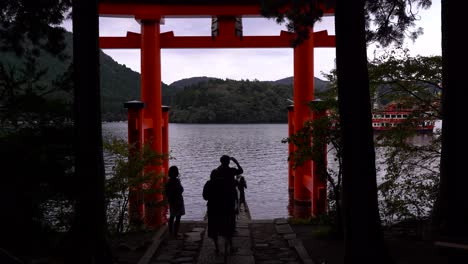 Crowds-of-tourists-taking-pictures-at-Hakone-Shrine-and-pirate-ship-passing-through-in-background