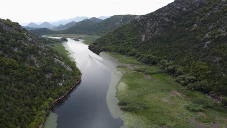 boat sails over crnojevica river to skadar lake at pavlova strana viewpoint, montenegro - slow aerial