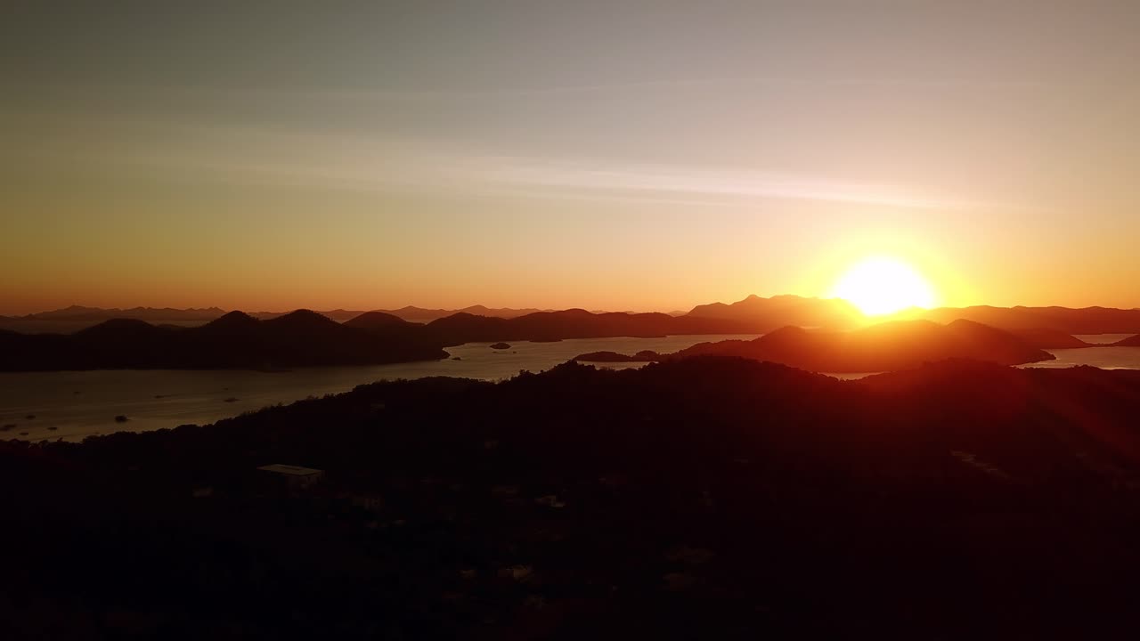 Tomada aérea de drone de um belo pôr do sol com vista para o oceano, ilhas e montanhas, em Palawan, Filipinas