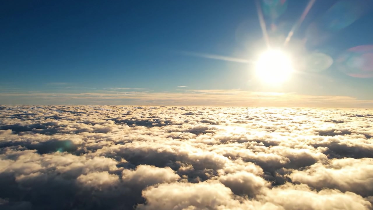 Una vista aerea mozzafiato del vasto paesaggio di nuvole illuminato dalla luce solare intensa, che mostra un paesaggio naturale sereno e tranquillo sopra l'orizzonte