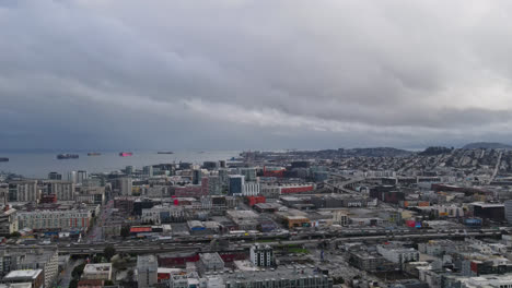 Toma-Panorámica-Aérea-Del-Paisaje-Urbano-De-San-Francisco-Con-Barcos-En-El-Mar-Durante-El-Día-Nublado---Tráfico-En-La-Carretera-Principal-De-La-Ciudad