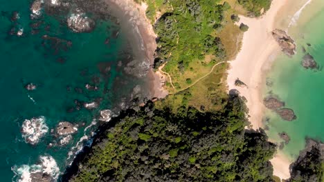 vista aérea de drones sobrevolando una estrecha península paradisíaca con playas y océano