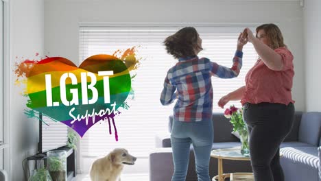 animation of rainbow heart and pride over lesbian couple dancing at home