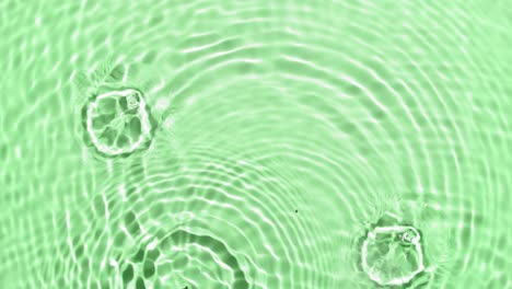 a lot of clear drops fall down on water surface creating circles