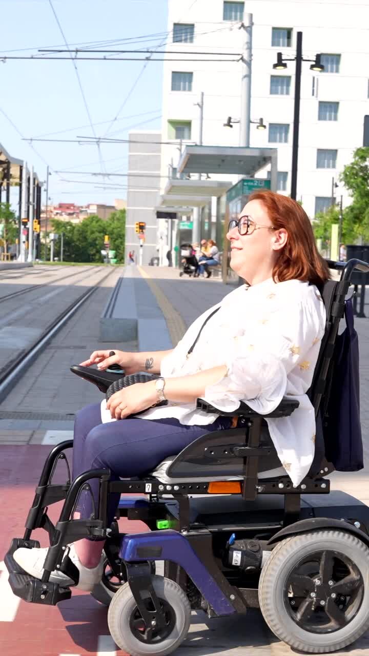 Woman in wheelchair at a tram station