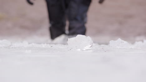 scuba diver in dry suit walks into subzero icy frozen lake for ice dive