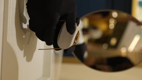 vertical salesperson removing luxury gold watch from protective cushion boutique store display to show customer