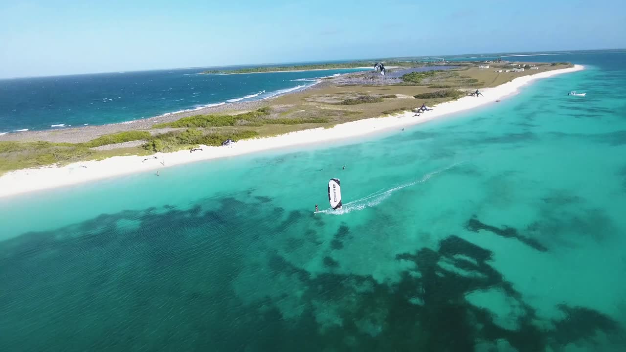 hombre kitesurf salto en agua azul mar caribe, vista aérea isla los roques crasqui