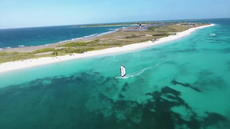 Man-KITESURF-JUMP-ON-BLUE-WATER-CARIBBEAN-SEA,-Aerial-view-Los-Roques-CRASQUI-ISLAND