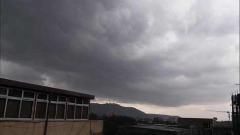 wide shot time laps for arat kilo in addis ababa the capital of ethiopia while the rainy clouds is passing by the city and throw its cargo on the city.