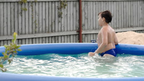 boy swimming in inflatable pool
