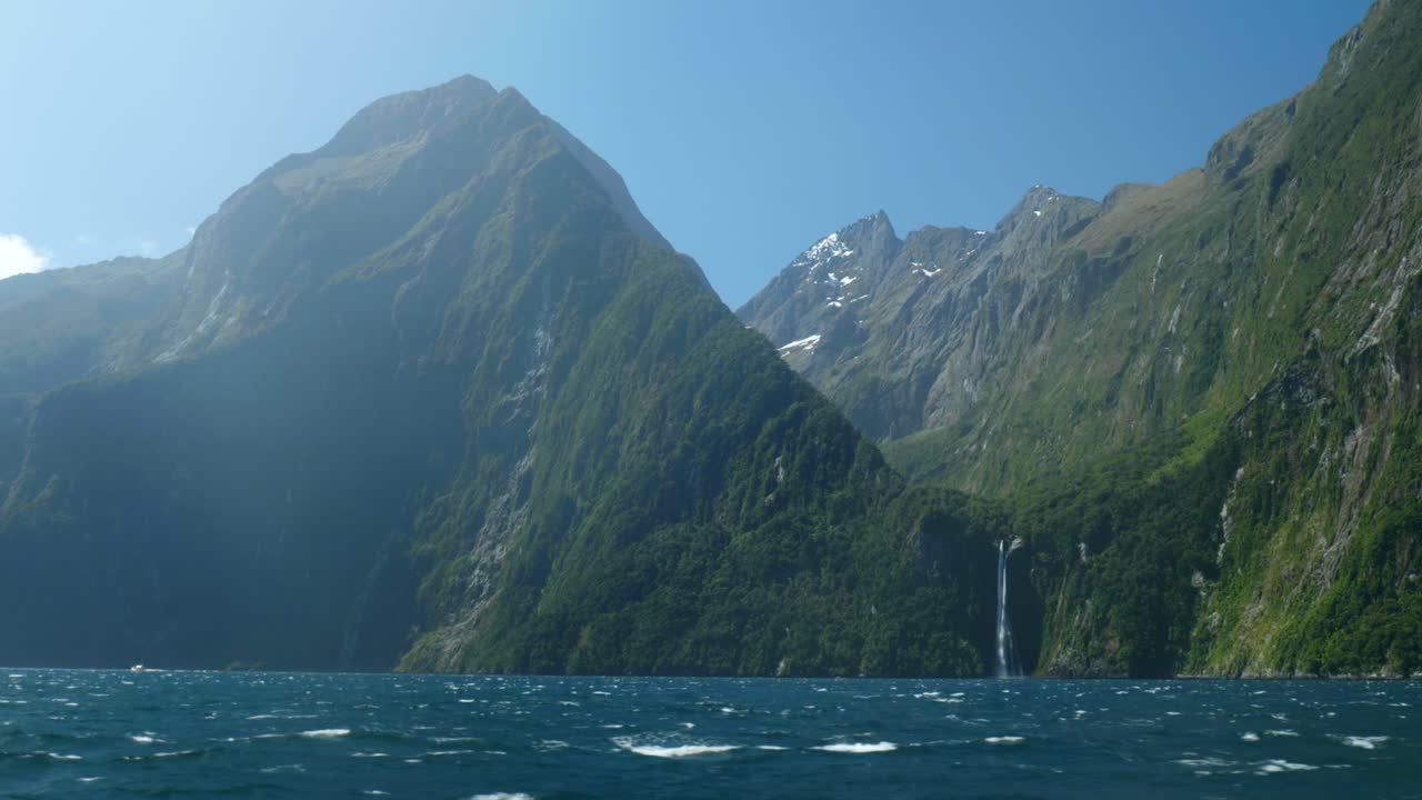 광활한 풍경은 밀포드 사운드 (milford sound) 의 놀라운 풍경에서 높은 산 에 자리 잡은 웅장한 폭포를 포착합니다.