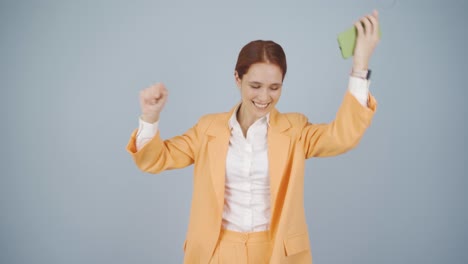 mujer de negocios bailando con el teléfono en la mano.