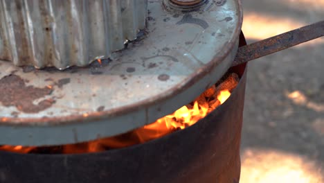 Close-up-Active-Burn-Barrel-with-Fire-Flame-during-Daytime-Outdoors-with-Cover-in-Chiang-Mai-Thailand