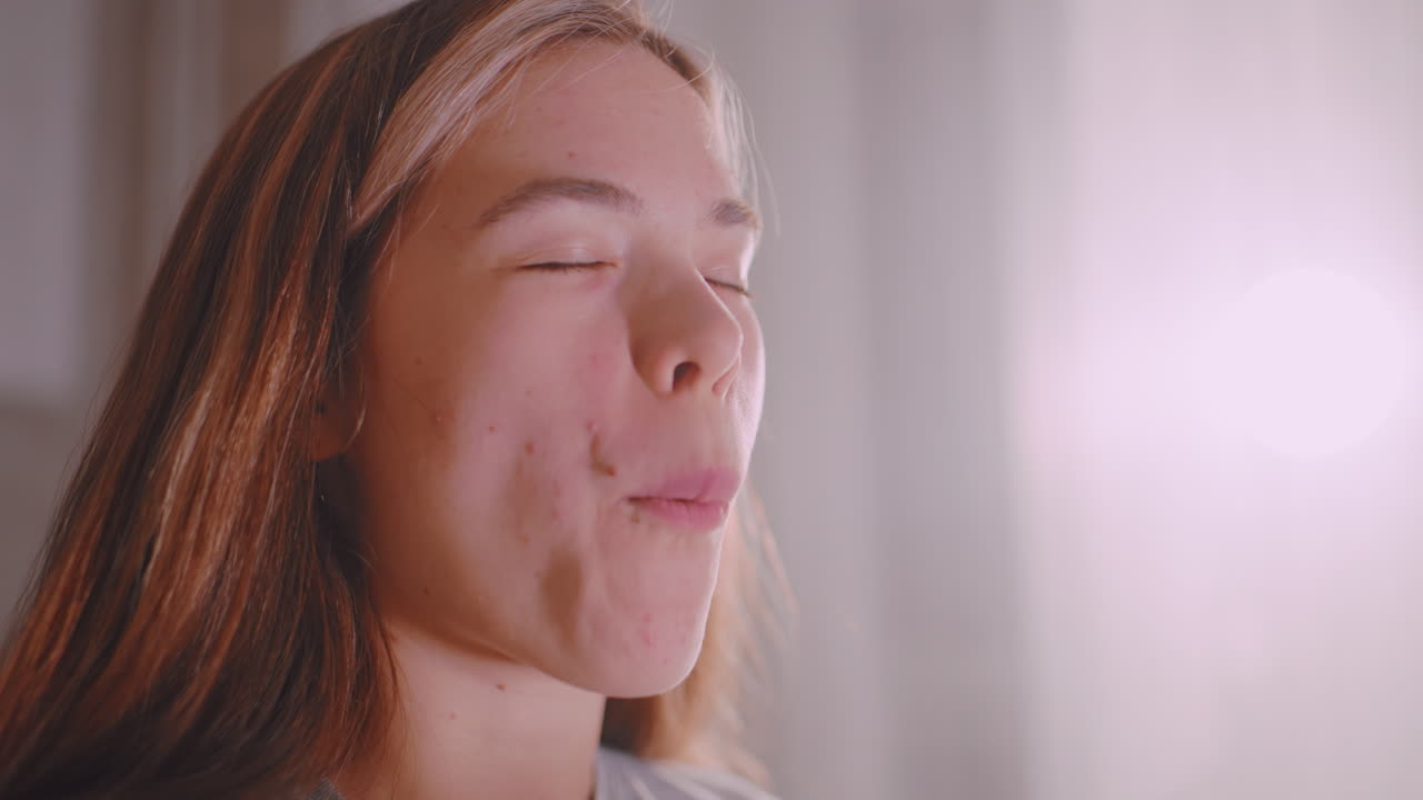 Close up of student savoring sandwich with thoughtful expression, hands holding bread filled with vegetables, natural daylight highlighting face and detail of eating