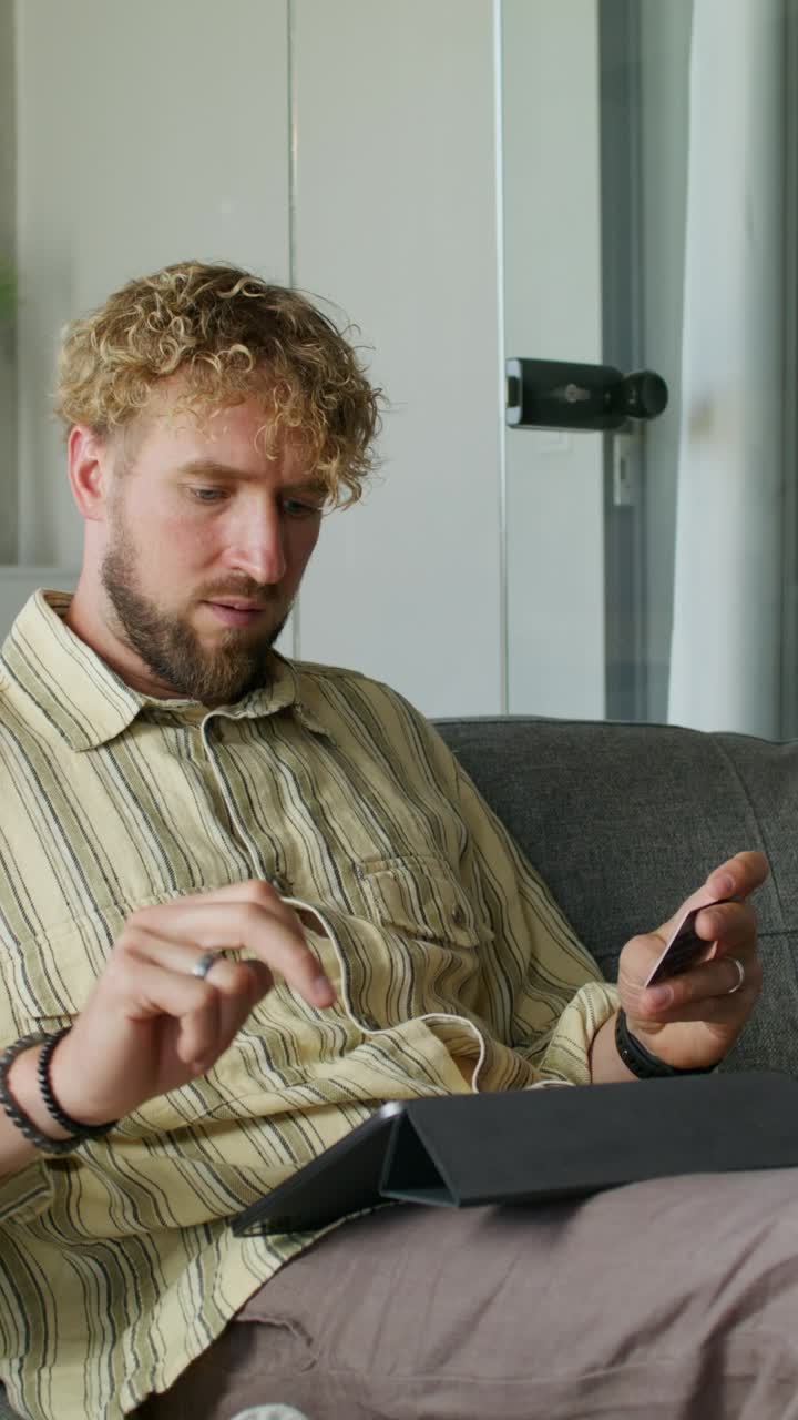 Man using a tablet and credit card at home