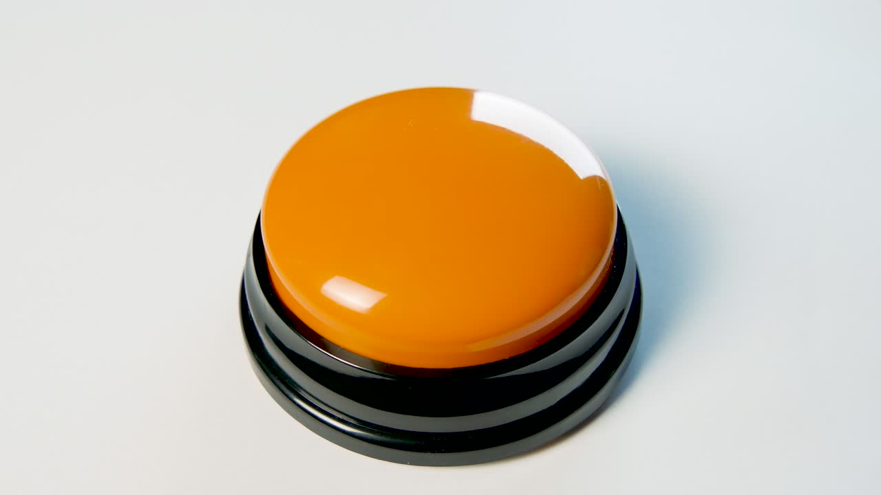 joven presionando el botón naranja con un dedo y la palma de la mano. presiona un botón redondo brillante, vista superior. activación, lanzamiento de algo. encender y apagar.