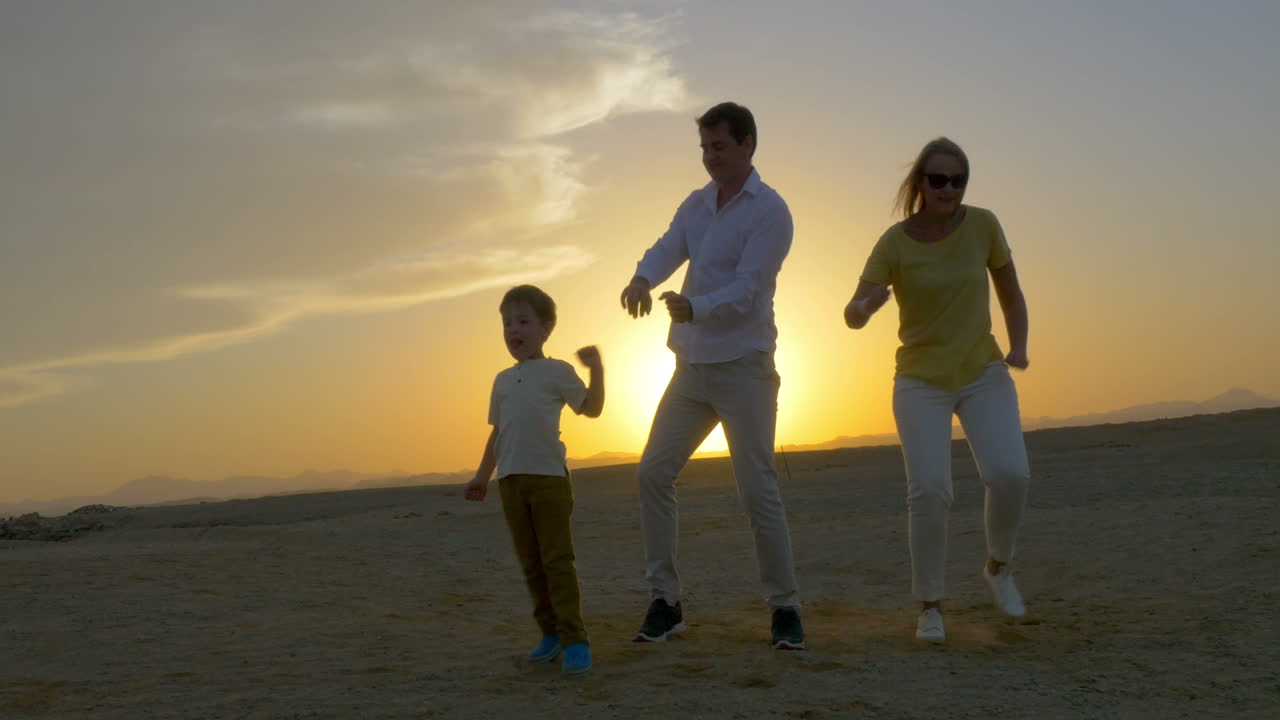 padres e hijos bailando al atardecer