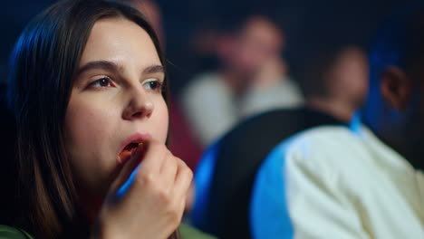 beautiful woman eating popcorn in movie theater