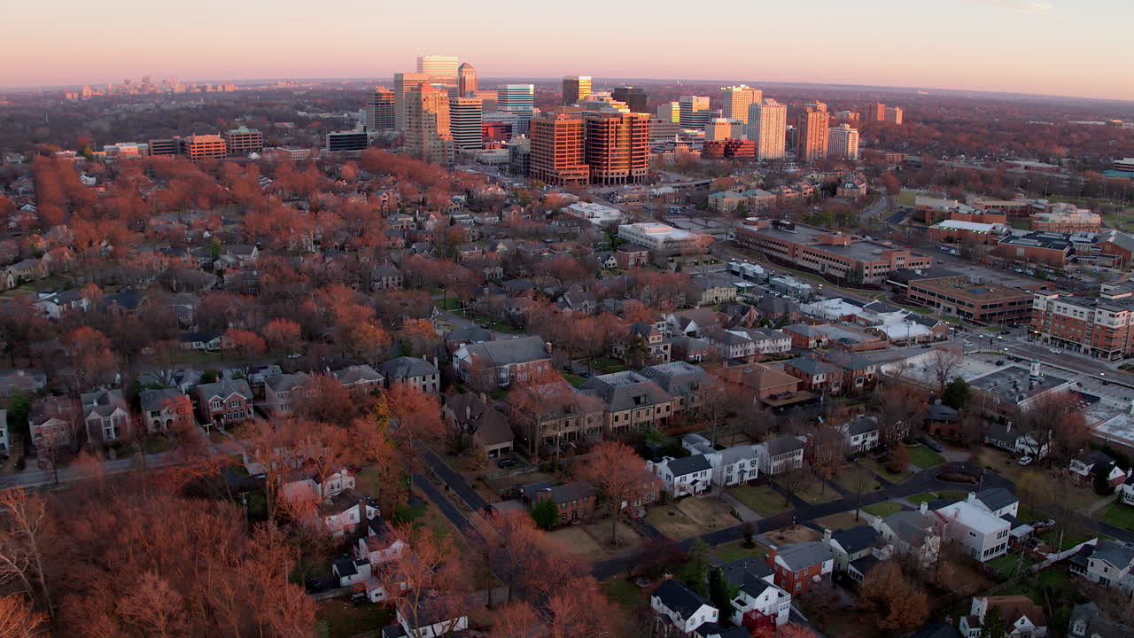 volar lejos del centro de la ciudad y del barrio urbano al atardecer