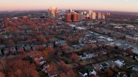 fly-away-from-downtown-city-and-urban-neighborhood-at-sunset