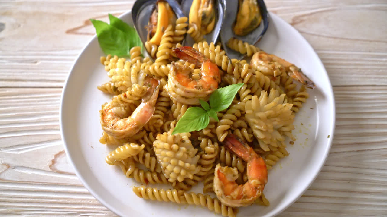 omrørt stegt spiral pasta med skaldyr og basilikumsauce - fusions mad stil