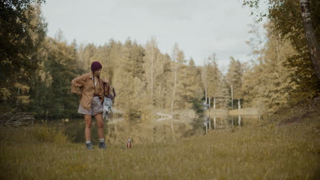 Woman-removing-backpack-and-keeping-on-grass