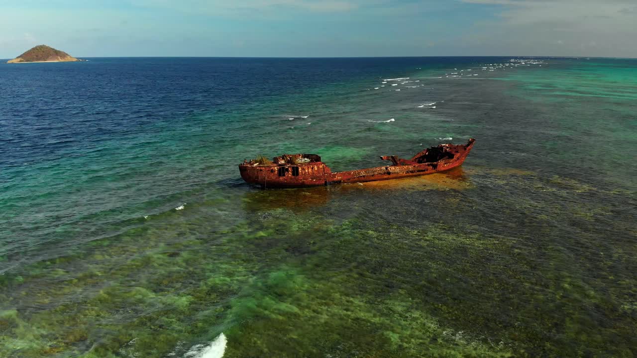 배경에 섬이 있는 얕은 암초에 난파선의 놀라운 공중