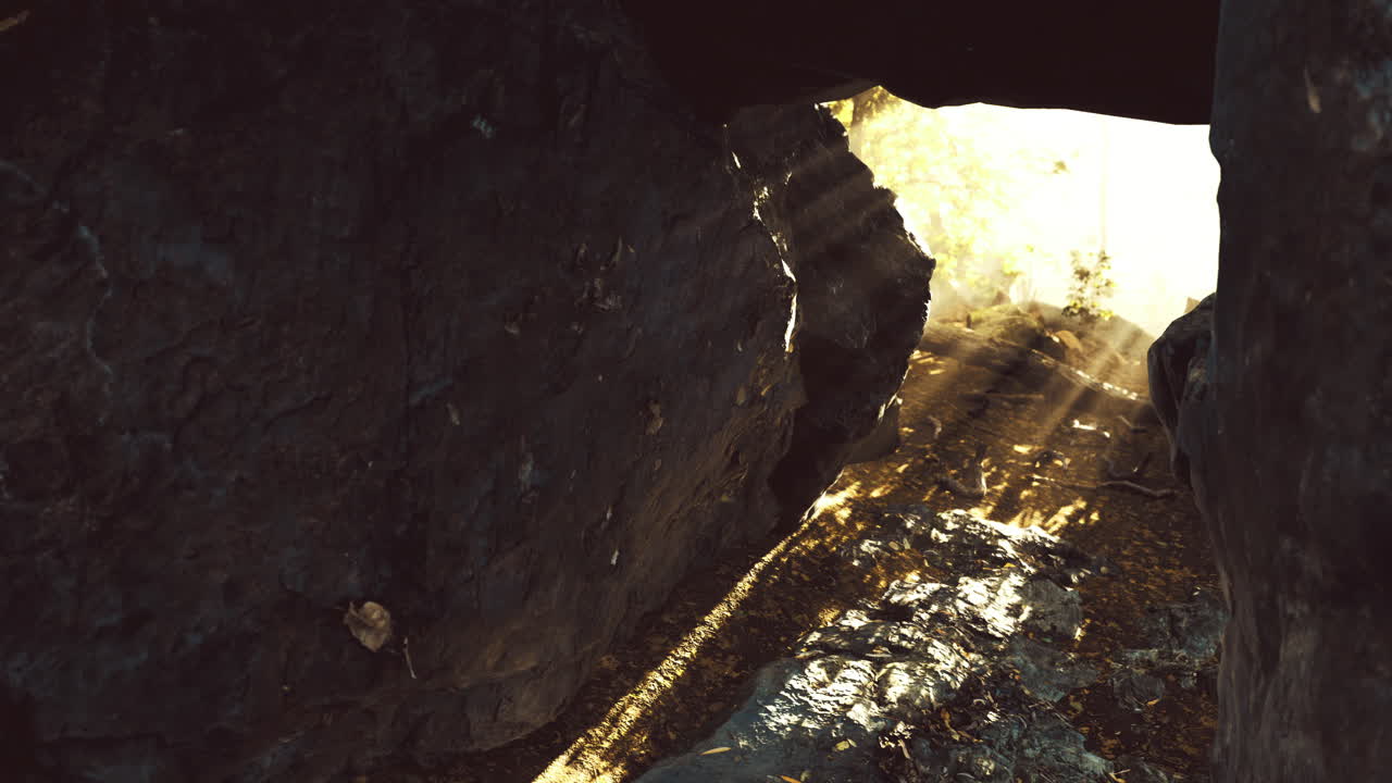 Sunlight streaming through rocky cave entrance during bright midday hours