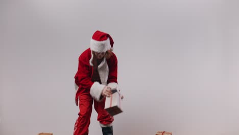 terrible santa jake tries to balance a stack of presents and fails miserably, then decides to down a can of beer