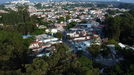 Aerial-drone-dolly-in-tilting-up-shot-of-the-Interlagos-neighborhood-in-the-south-of-São-Paulo,-Brazil-from-the-man-made-Guarapiranga-Reservoir-with-trees,-and-residential-houses-on-a-fall-evening