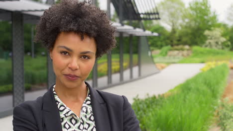 portrait of serious businesswoman standing outside modern office building