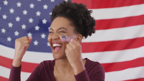 Video-Einer-Aufgeregten-Afroamerikanischen-Frau-Mit-US-Flagge,-Die-Sich-Ein-Spiel-Im-Fernsehen-Ansieht