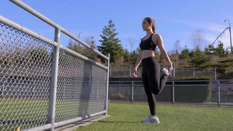 joven atlética estirando los isquiotibiales antes de correr de par en par