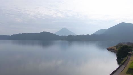 Flying Up Above Yellow Nanohana Flowers to Reveal Ikeda Lake and Kaimondake Mountain