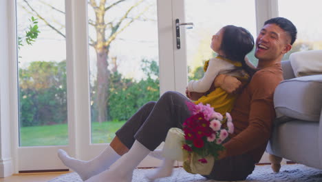 Familia-En-Casa-Con-Papá-Recibiendo-Un-Ramo-De-Flores-En-Su-Cumpleaños-Por-Parte-De-Su-Hija