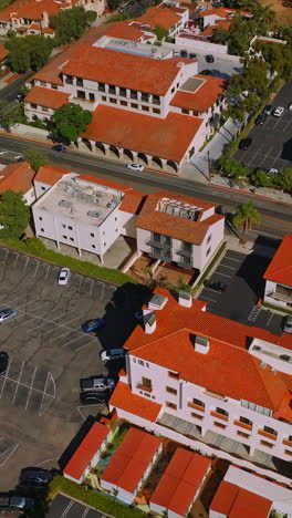 panorama of beautiful sunny city of santa barbara, united states. drone footage descending over the street. hills and blue sky at backdrop. vertical video