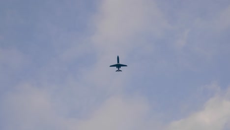 bottom view of an airplane flying in clouded sky