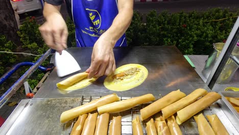 el vendedor prepara mini rollos de panqueque en bangkok