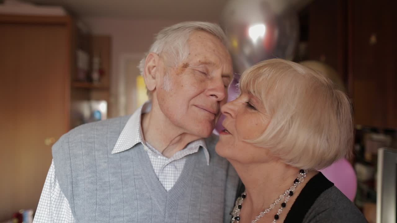 Portrait of a happy grandfather and grandmother who lovingly looks at eachother