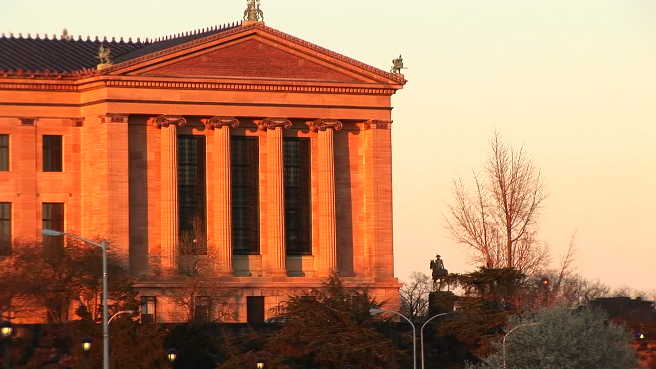 황금시간대에 빛나는 이온 기둥이 있는 신고전주의 건물
