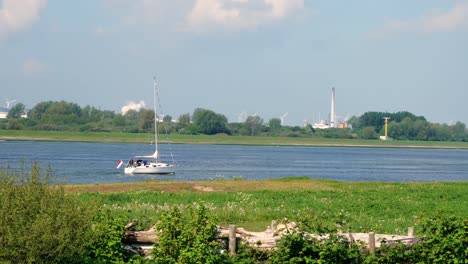 un paisaje holandés con un río y un barco marino en el frente
